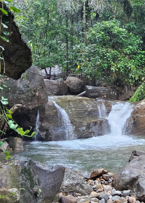 Waterfall spilling into a clear natural pool among the rocks